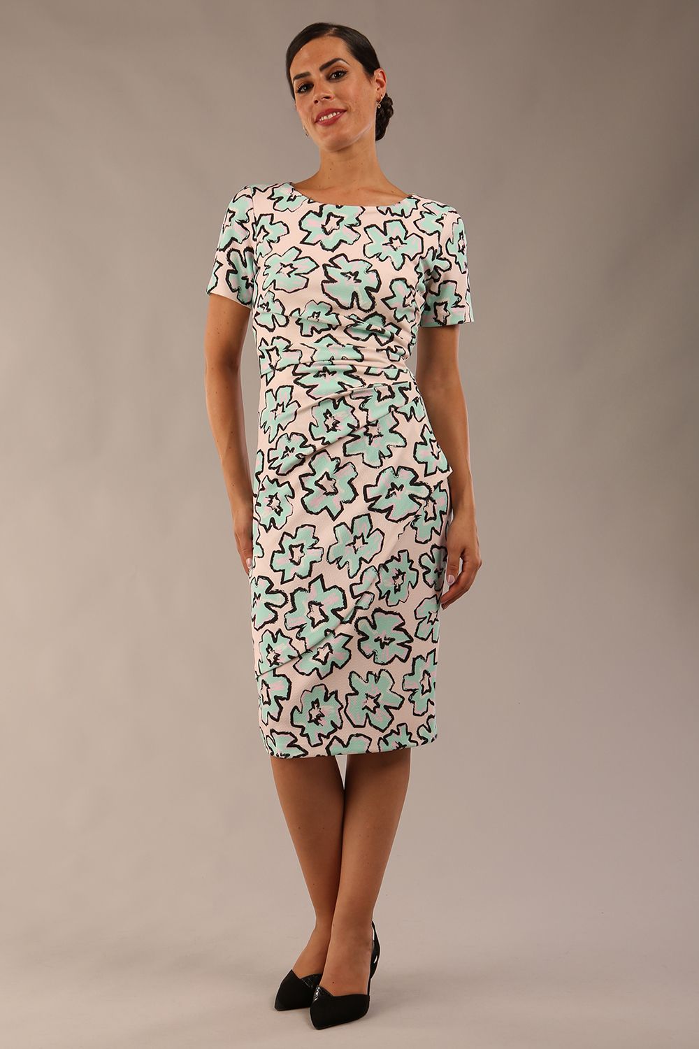 model wearing a  diva catwalk Katia pencil dress with a cascading layered skirt and stunning floral patterns with shor sleeves and knee length in geometric floral print