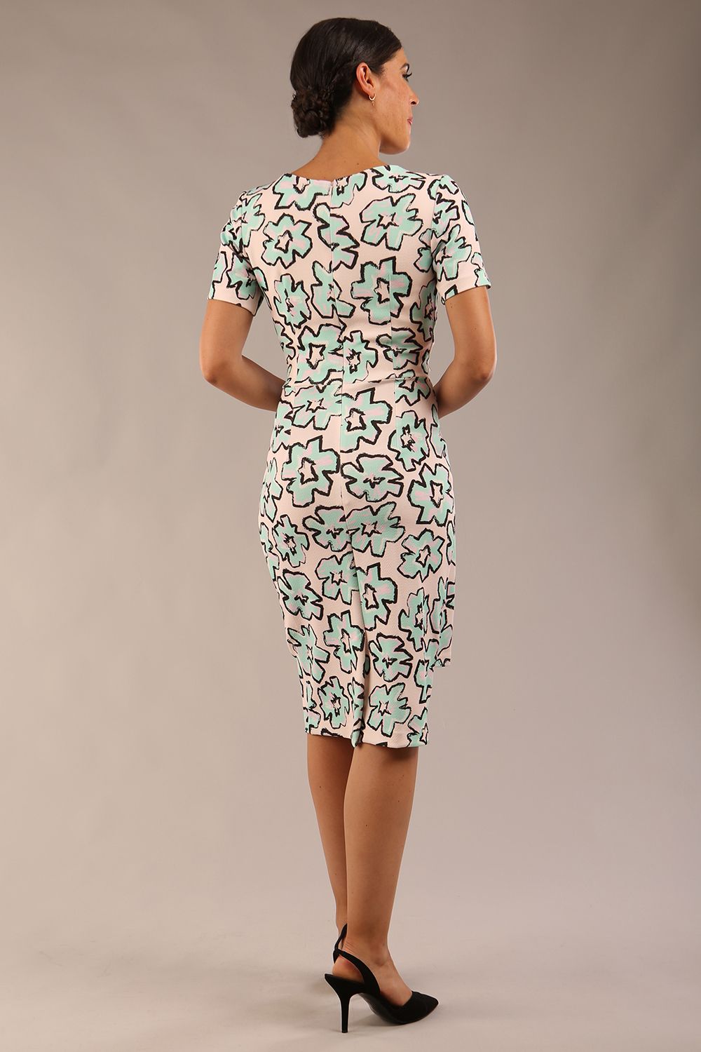 model wearing a  diva catwalk Katia pencil dress with a cascading layered skirt and stunning floral patterns with shor sleeves and knee length in geometric floral print