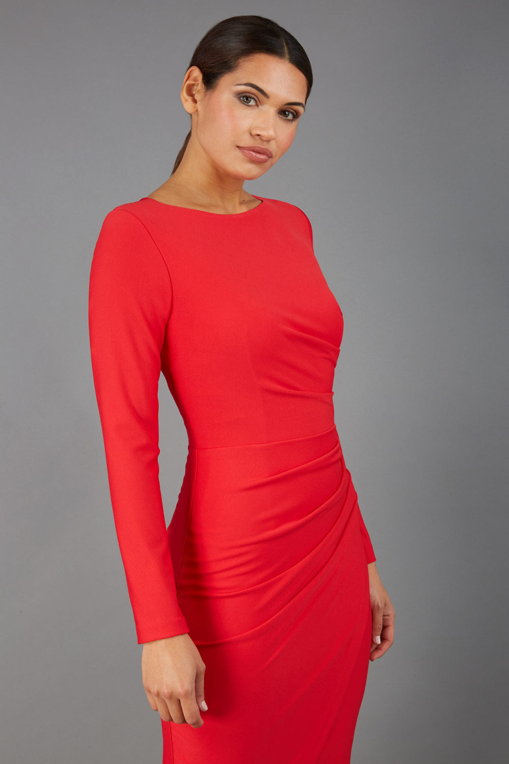 brunette model wearing diva catwalk pencil skirt dress sleeved with  pleating on side in electric red colour front