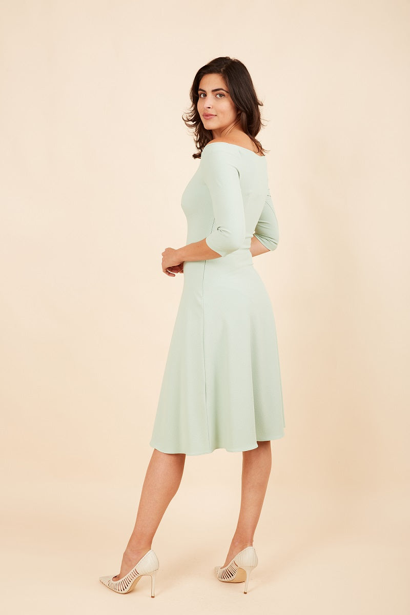 brunette model is wearing diva catwalk off shulder swing a-line islay dress with sleeves in deco green back