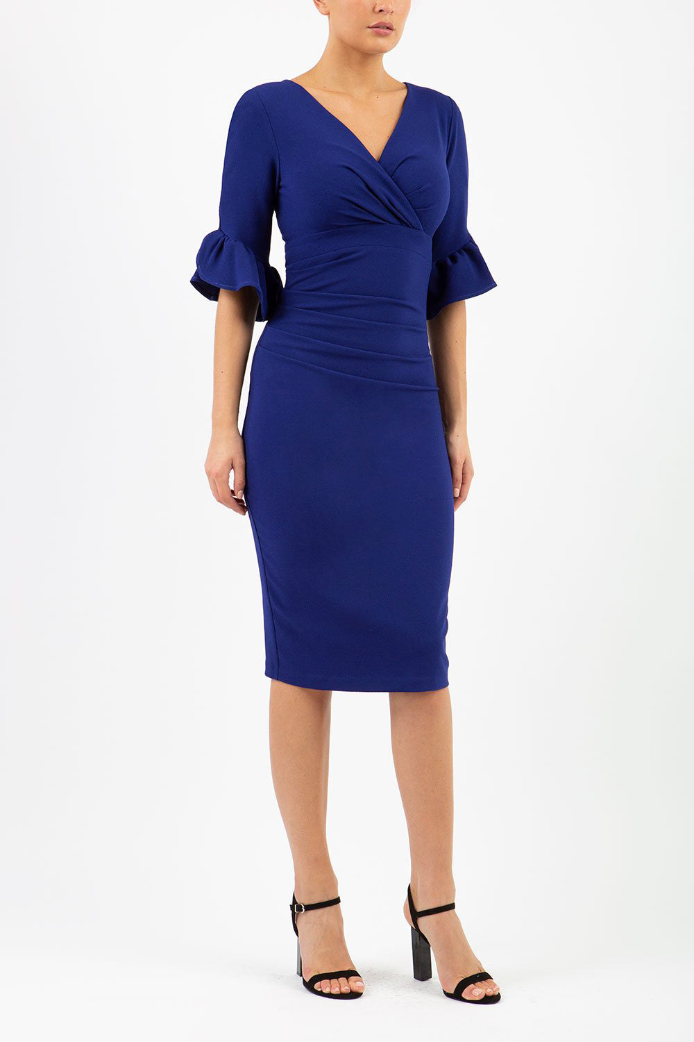 brunette model is wearing diva catwalk hollie pencil dress with frilled flute sleeve and low v-neck cut in blue front