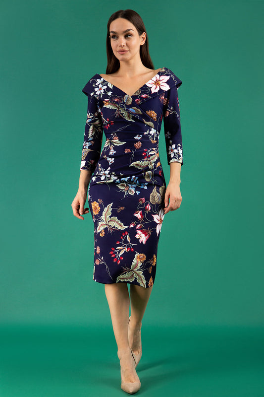 A brunette model is wearing a bi stretch pencil print wildflower dress by diva catwalk