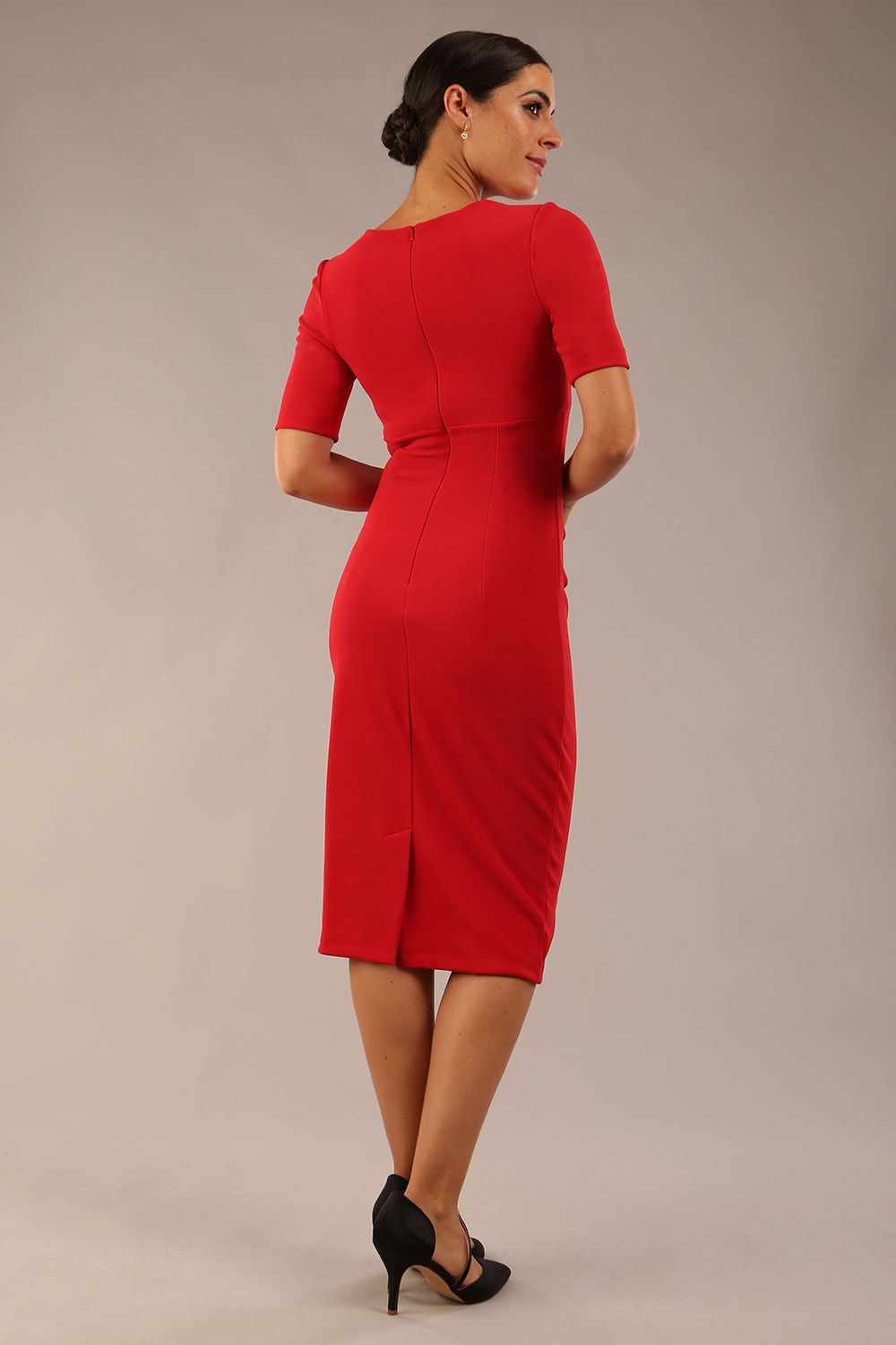 model is wearing Diva Catwalk Lydia Short Sleeve Pencil Dress with pleating across the tummy and split neckline in True Red back