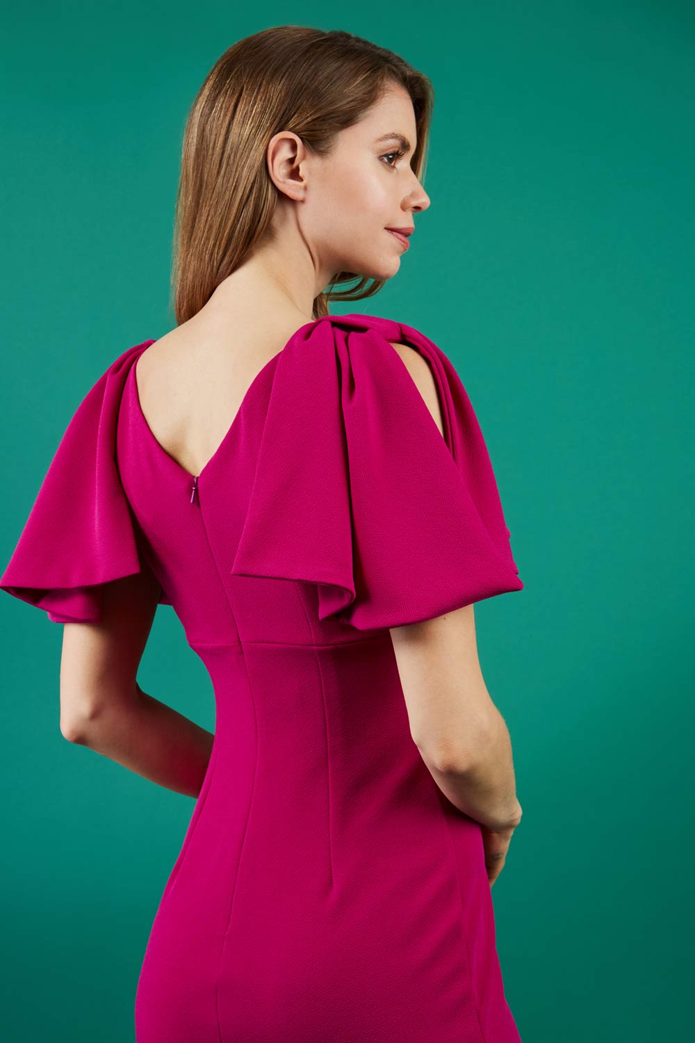 brunette model is wearing diva catwalk hermione pencil dress with tie shoulder details and empire waistline in magenta back