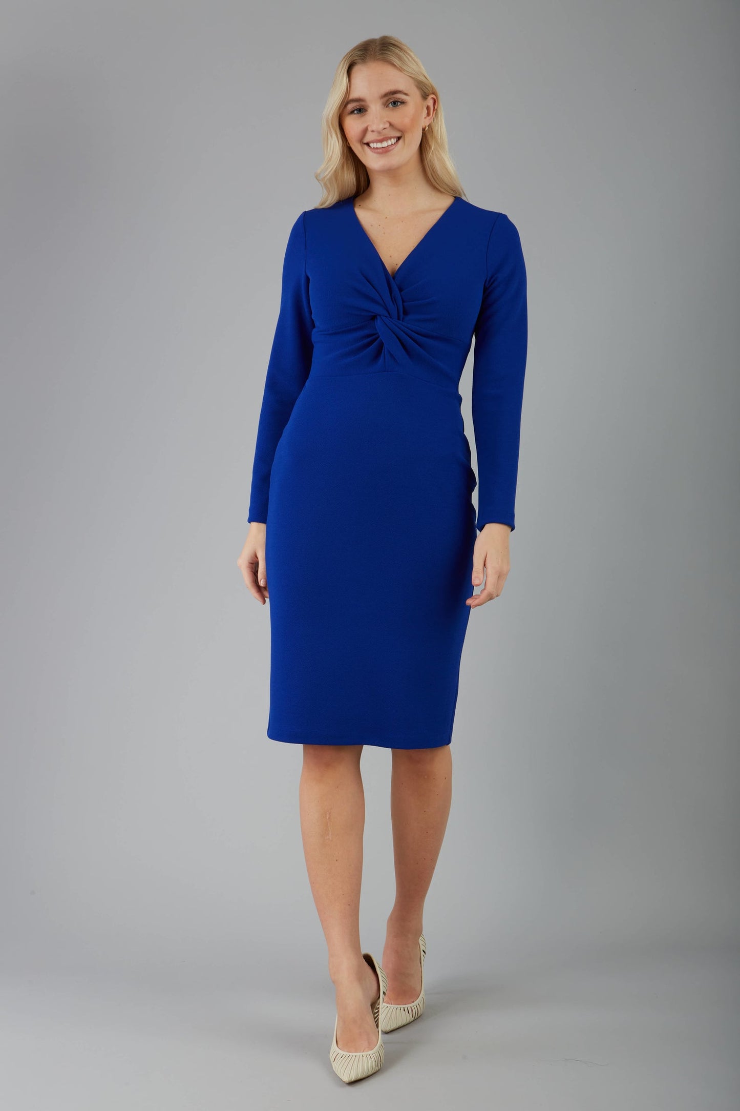 blonde model is wearing diva catwalk gately pencil dress with long sleeves and twisted low v-neck in royal blue front